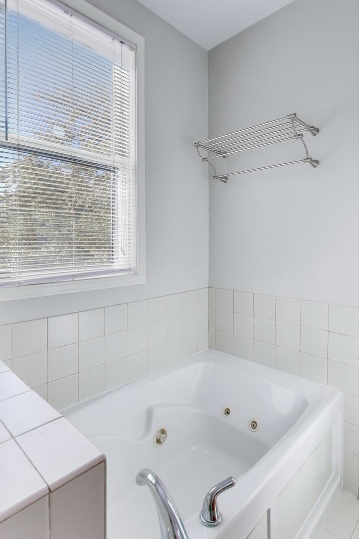 125 North Rose Street, Unit E Palatine, IL 60067 - Photo 17 of 28 a bathroom with a tub a window and a shower