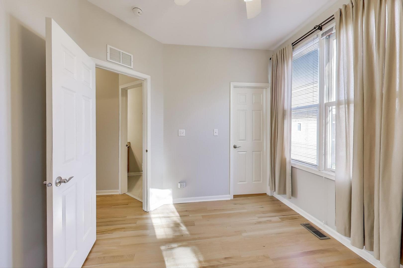 125 North Rose Street, Unit E Palatine, IL 60067 - Photo 19 of 28 a view of an empty room with wooden floor and a window