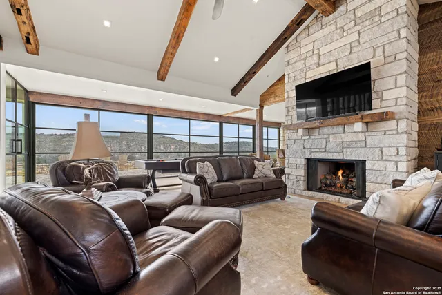 a dining room with furniture large windows and wooden floor