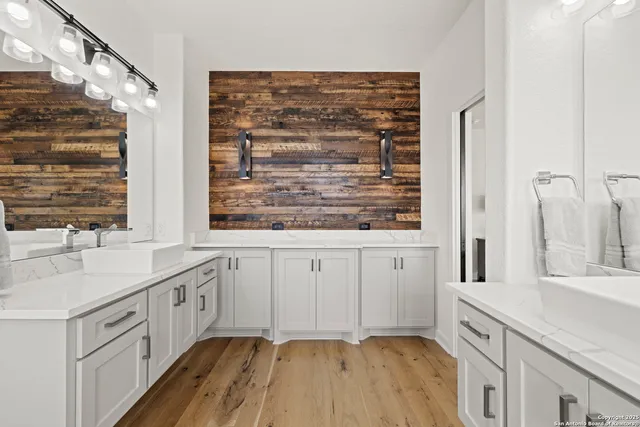 a bathroom with a granite countertop sink a toilet a mirror and shower