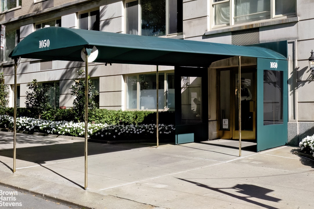 1050 5th Avenue, Unit 15C Manhattan, NY 10028 - Photo 14 of 15 a view of a brick building with a bench in front of building