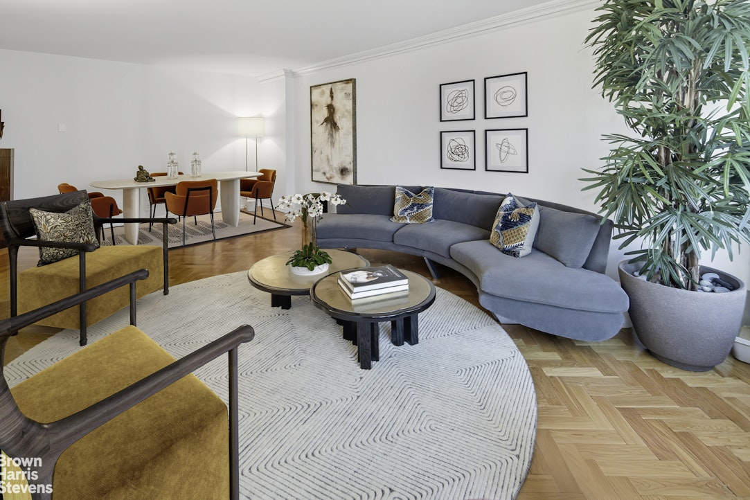 1050 5th Avenue, Unit 15C Manhattan, NY 10028 - Photo 5 of 15 a living room with furniture and a potted plant