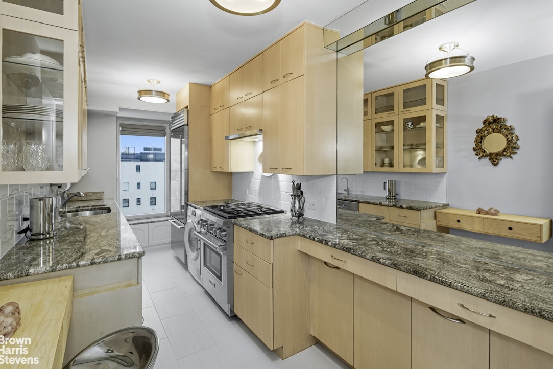 1050 5th Avenue, Unit 15C Manhattan, NY 10028 - Photo 6 of 15 a bathroom with a granite countertop sink and a mirror