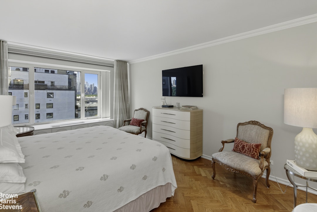 1050 5th Avenue, Unit 15C Manhattan, NY 10028 - Photo 9 of 15 a bedroom with furniture and a flat screen tv