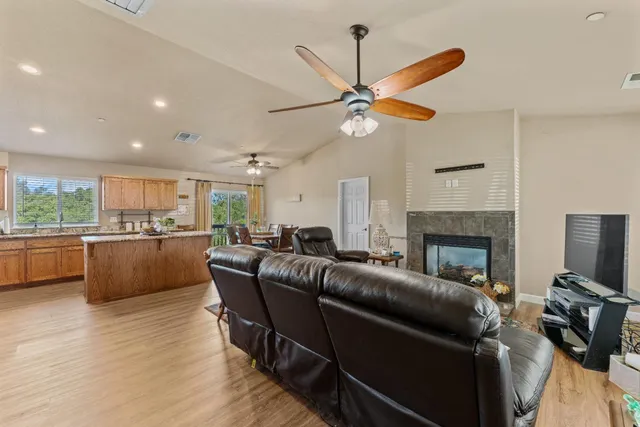 a living room with furniture a fireplace and a ceiling fan