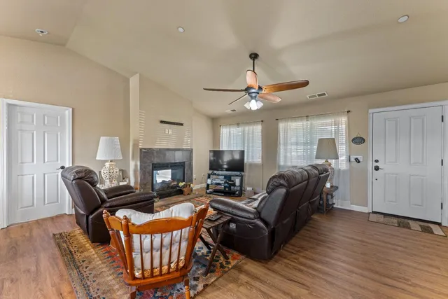 a living room with furniture a fireplace and wooden floor