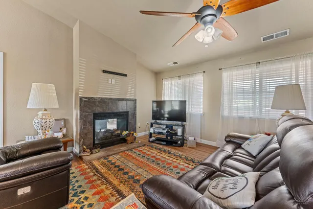 a living room with furniture a flat screen tv and a fireplace