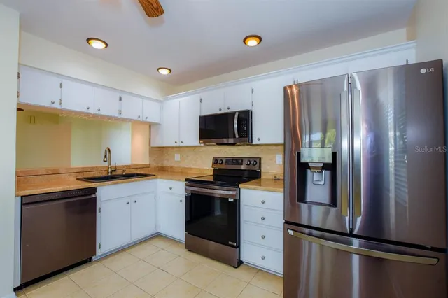 a kitchen with granite countertop a refrigerator and a sink