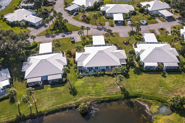 an aerial view of a house with swimming pool and large trees