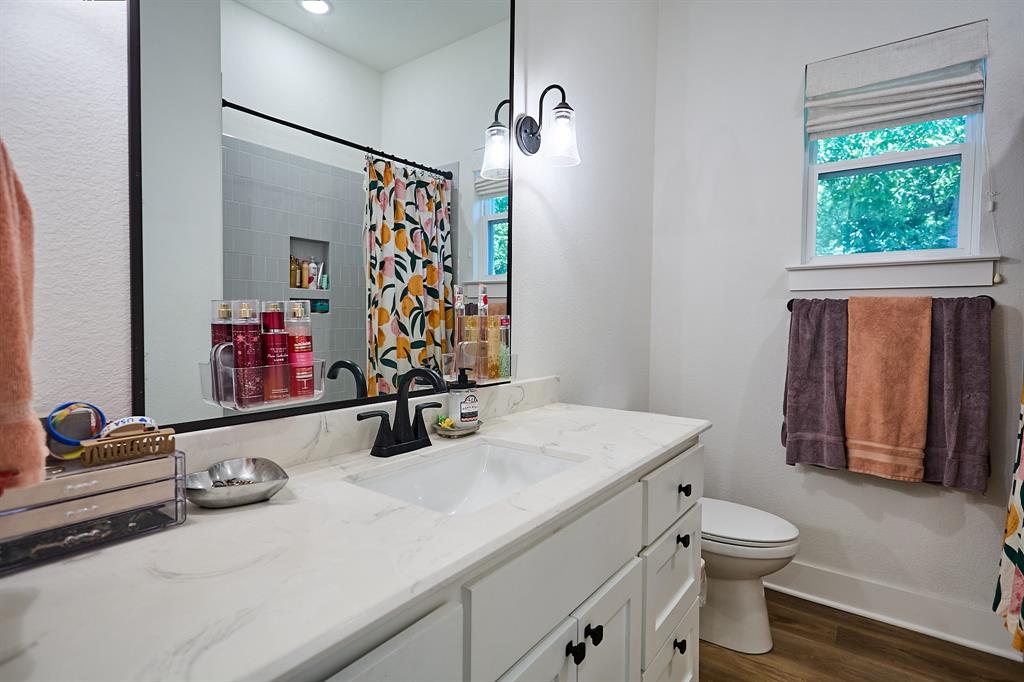 358 Glade Valley Road Azle, TX 76020 - Photo 21 of 35 Bathroom featuring a wide single vanity with an integrated sink, a large wall-mounted mirror, and a window with a fabric valance