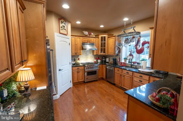 a kitchen with stainless steel appliances granite countertop a refrigerator and a stove