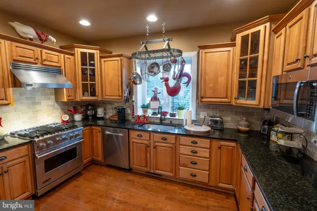 a kitchen with stainless steel appliances granite countertop a stove and a sink