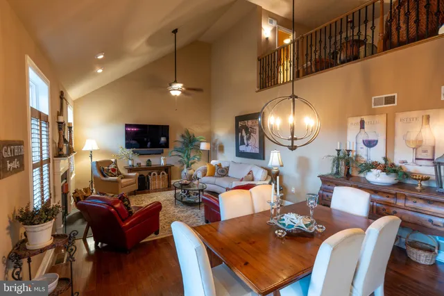 a living room with furniture kitchen view and a chandelier