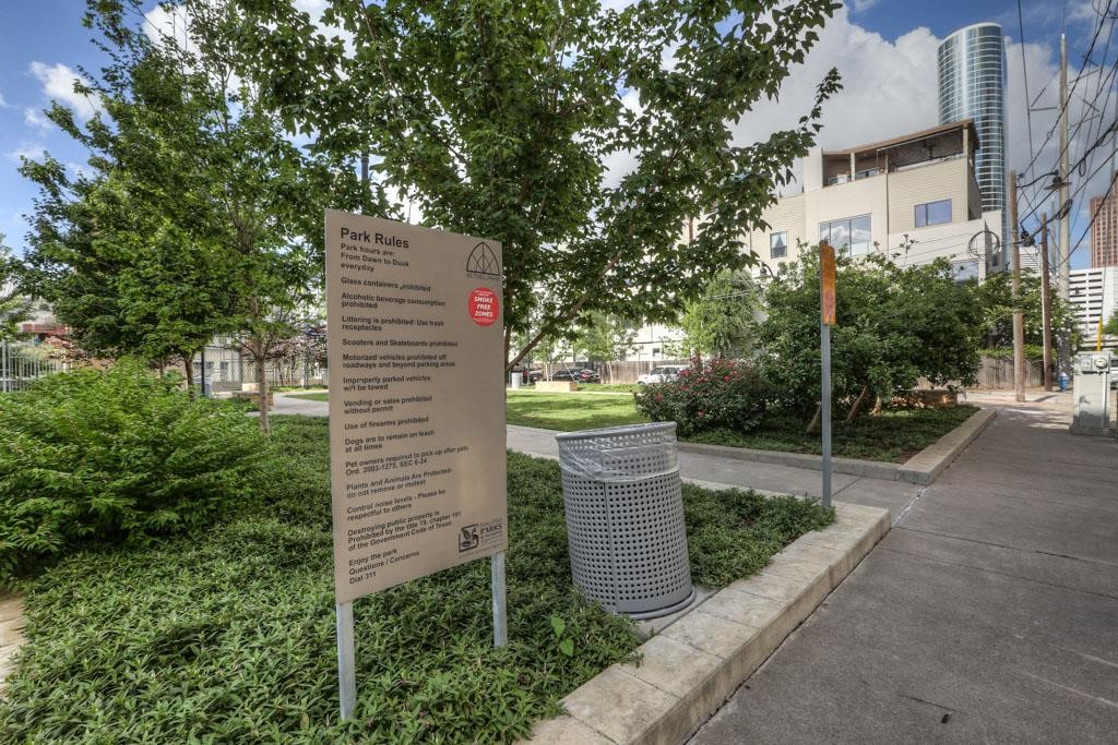 816 Ruthven Street Houston, TX 77019 - Photo 38 of 39 This photo features a well-maintained urban park with clear rules displayed on a sign. The area is landscaped with greenery and has nearby modern residential buildings, offering a serene and convenient community space.