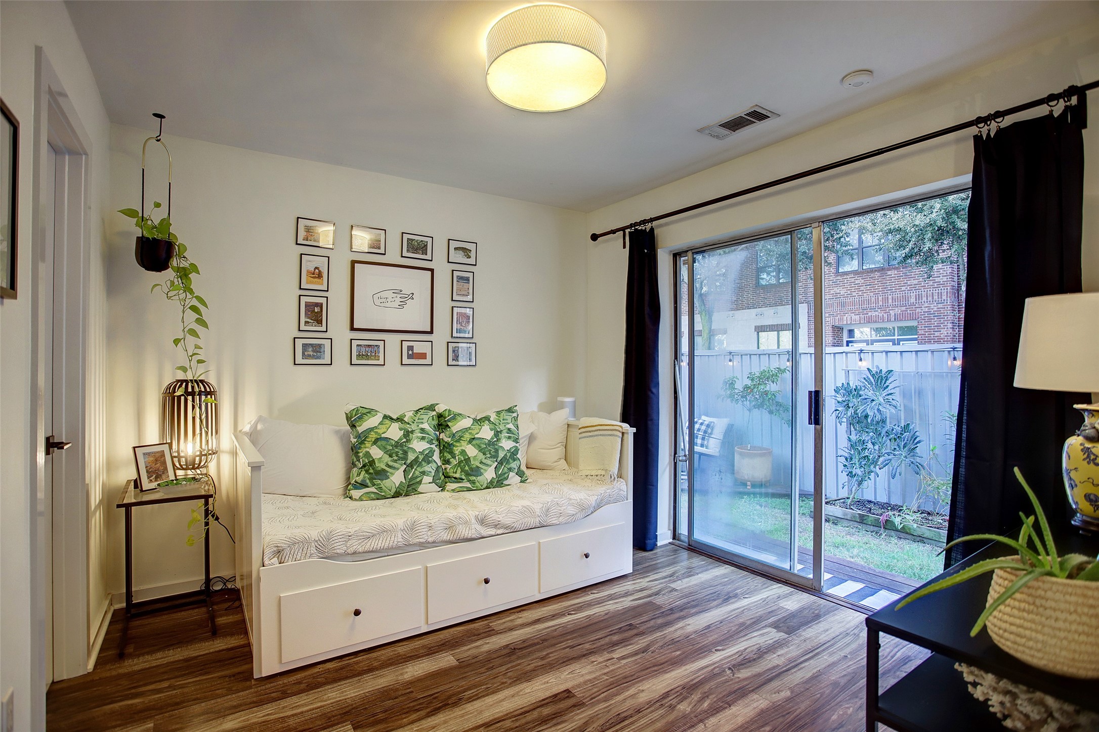 816 Ruthven Street Houston, TX 77019 - Photo 4 of 39 Discover the charm of this first-floor bedroom, featuring seamless indoor-outdoor living with large sliding doors that open to a serene garden view, perfect for relaxation and tranquility.