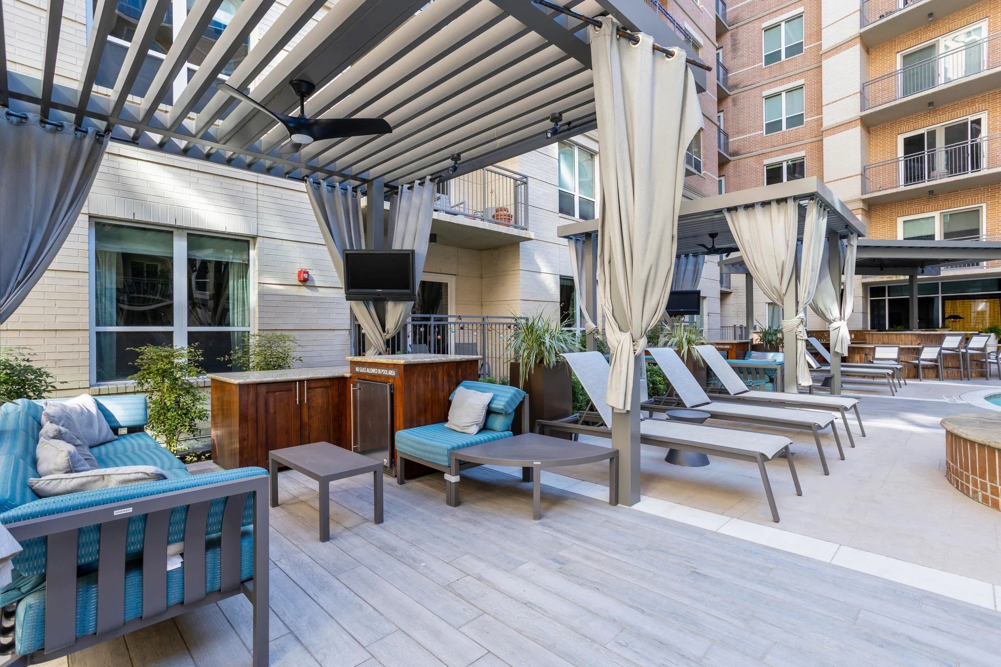 2724 Kipling Street, Unit 436 Houston, TX 77098 - Photo 24 of 29 For more social gatherings, the courtyard also features a second, larger pavilion outfitted with a bar area. The chic privacy curtains and wood-look tile flooring create a sanctuary for both relaxation and upscale outdoor entertaining, allowing you to seamlessly transition from quiet afternoon reading to hosting a vibrant sunset happy hour with friends.