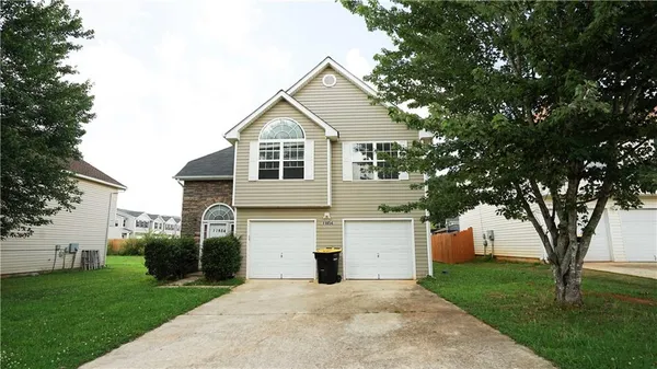 a front view of a house with a yard and a garage