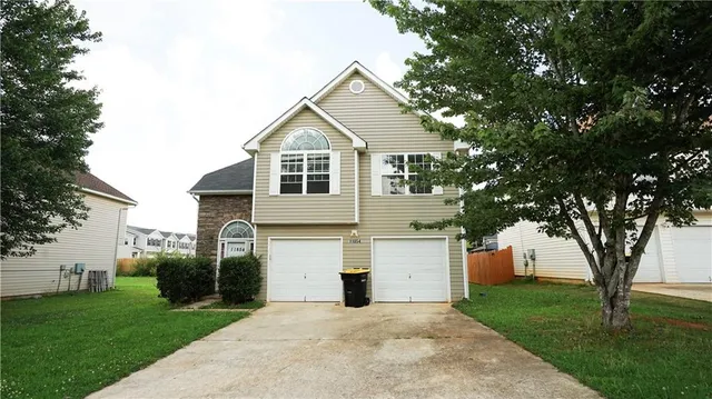 a front view of a house with a yard and a garage