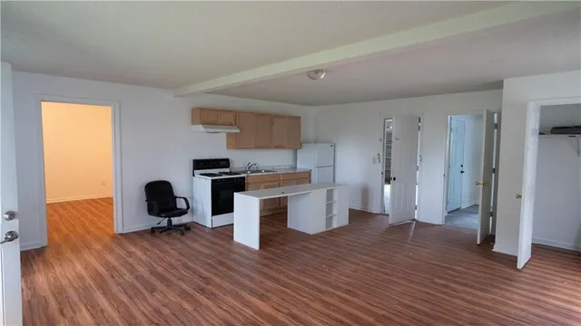 a kitchen with a refrigerator and white cabinets