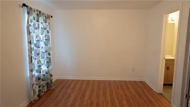 a view of a small space with wooden floor and a window