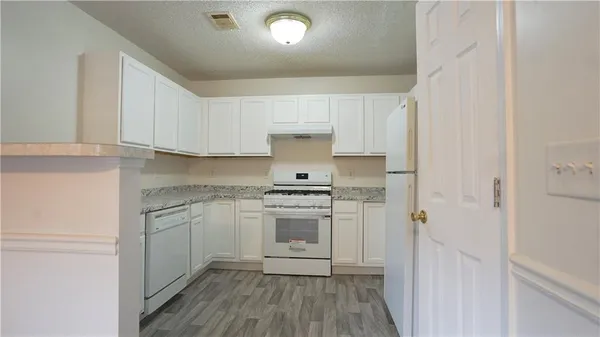 a kitchen with a stove oven and white cabinets