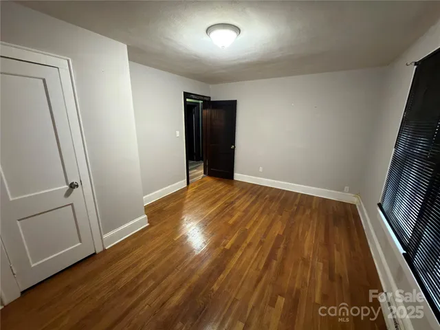 an empty room with wooden floor and entrance