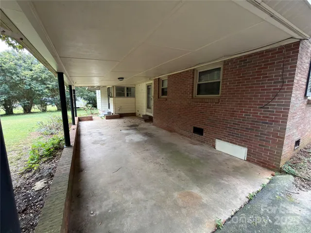 a view of a patio with a table and chairs next to a yard