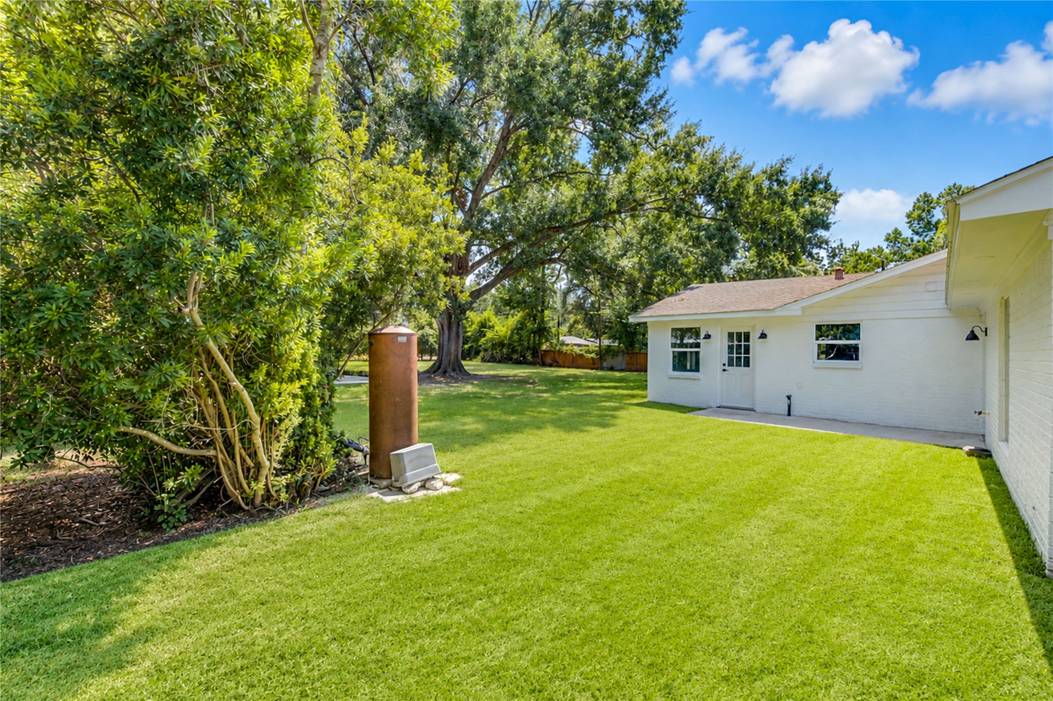 5411 Logston Lane Spring, TX 77389 - Photo 45 of 50 Expansive backyard with lush lawn and mature trees, providing ample space for outdoor activities and relaxation.