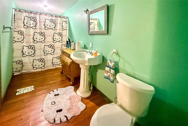 a bathroom with a toilet sink and mirror