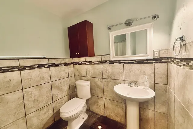 a bathroom with a toilet sink and mirror