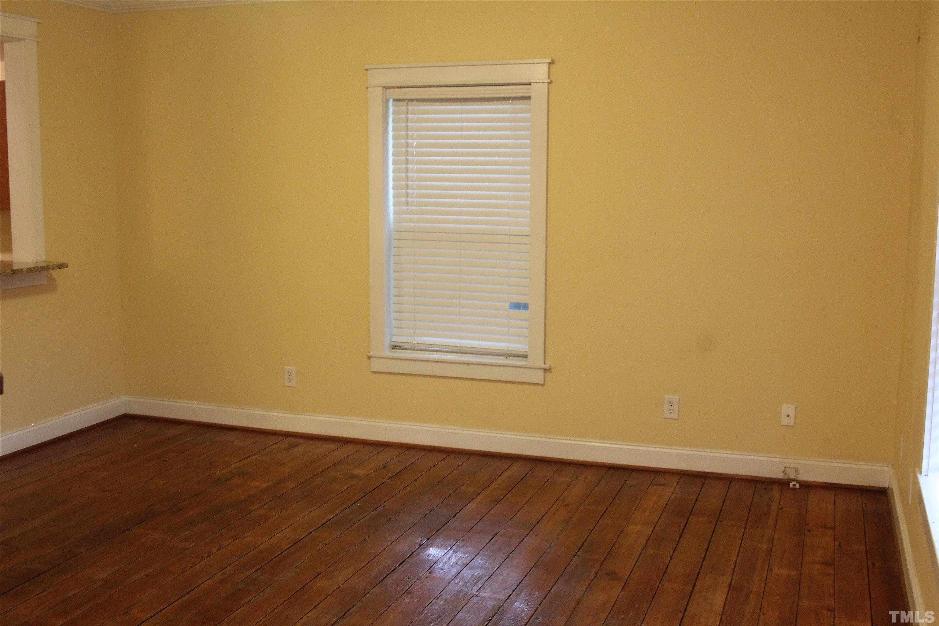 815 East Davie Street Raleigh, NC 27601 - Photo 4 of 21 a view of an empty room with wooden floor and a window
