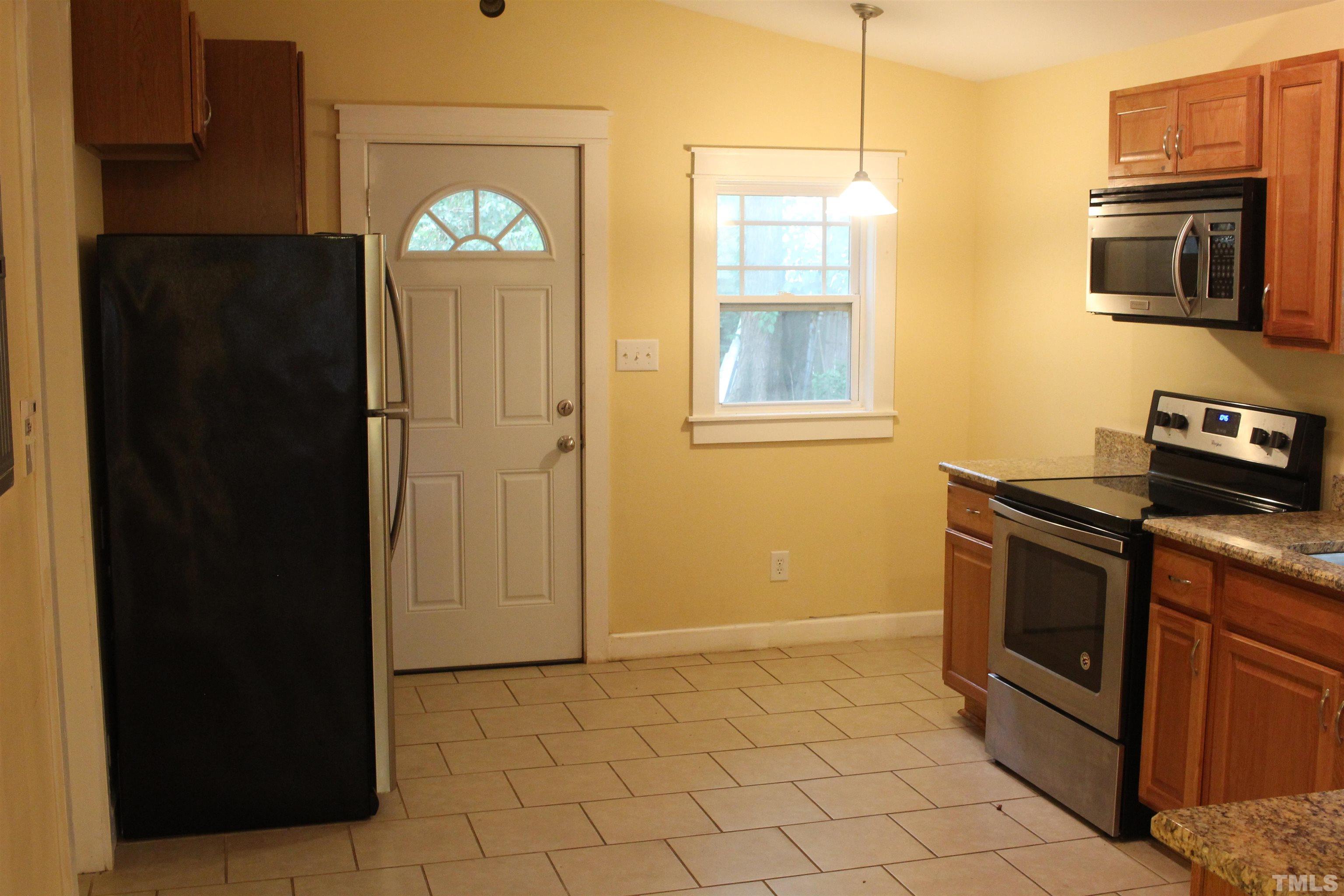 815 East Davie Street Raleigh, NC 27601 - Photo 7 of 21 a kitchen with granite countertop a refrigerator stove and microwave