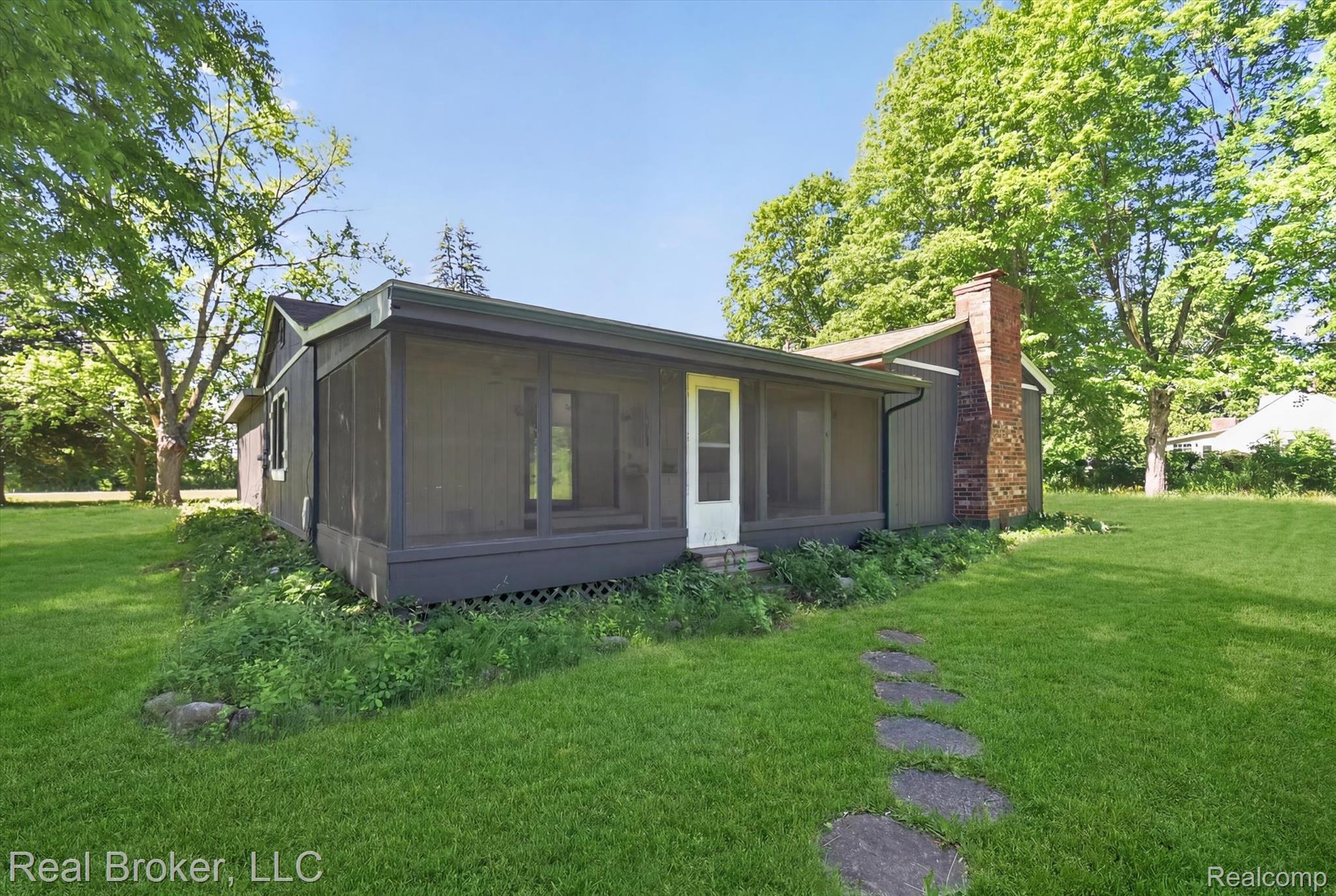 48050 Hull Road Belleville, MI 48111 - Photo 38 of 39 Single-story residence featuring a screened porch entry, a prominent brick chimney, and a stone paver pathway