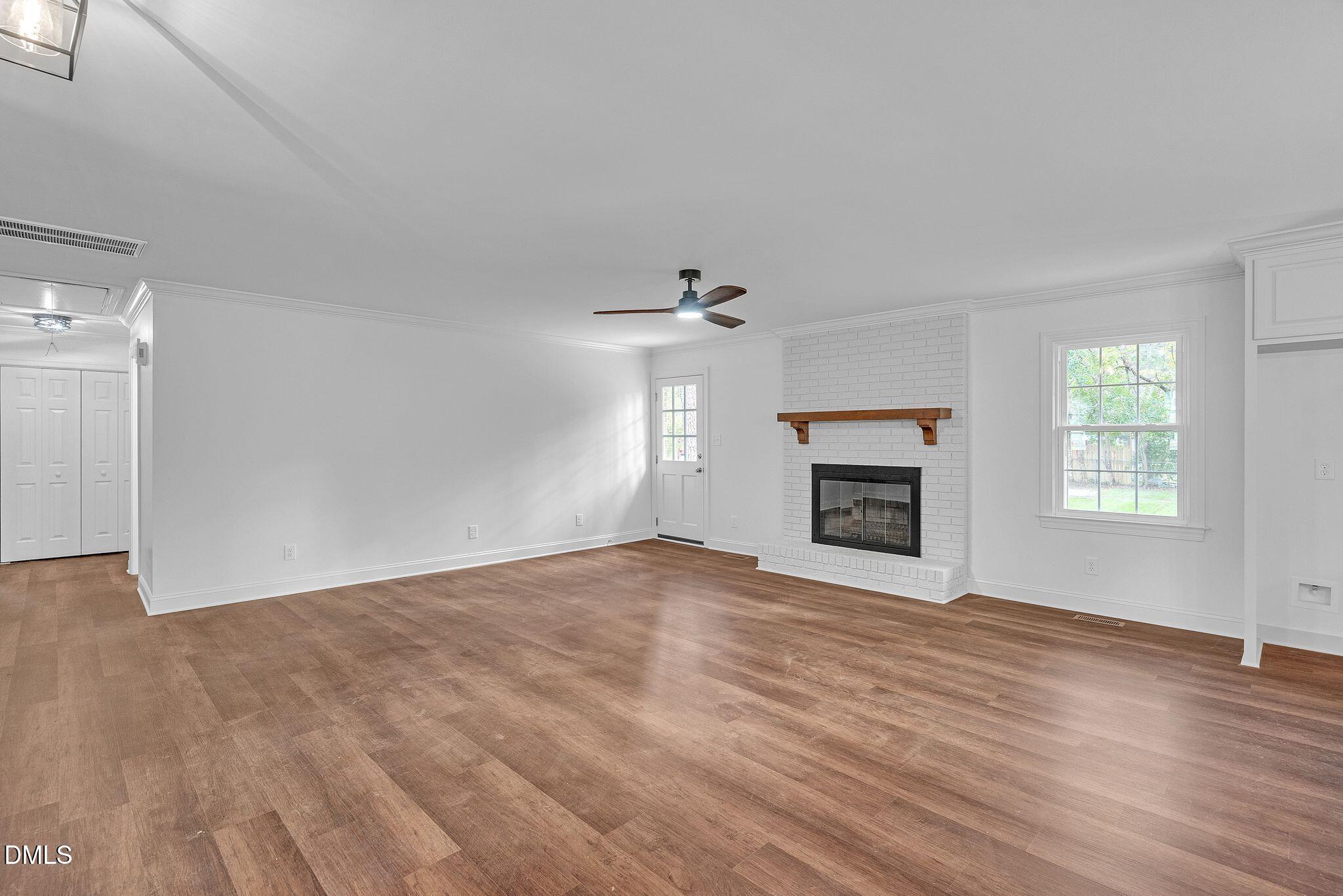 1219 Queen Anne Road Northwest Wilson, NC 27896 - Photo 20 of 26 wooden floor fireplace and windows in an empty room