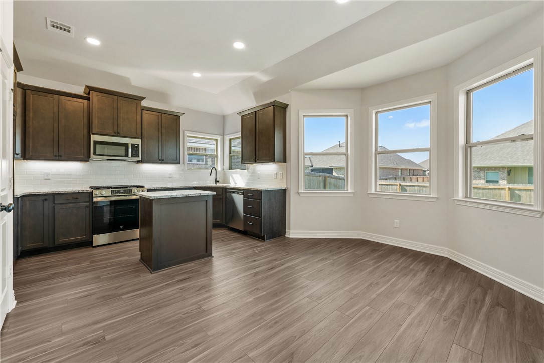 2813 Spector Drive Bryan, TX 77808 - Photo 13 of 42 a kitchen with stainless steel appliances a sink counter space cabinets and a wooden floor