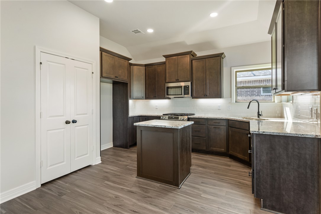 2813 Spector Drive Bryan, TX 77808 - Photo 15 of 42 a kitchen with stainless steel appliances granite countertop a sink stove and refrigerator
