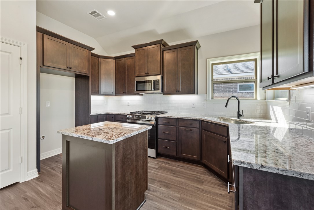 2813 Spector Drive Bryan, TX 77808 - Photo 16 of 42 a kitchen with stainless steel appliances granite countertop a sink stove and refrigerator