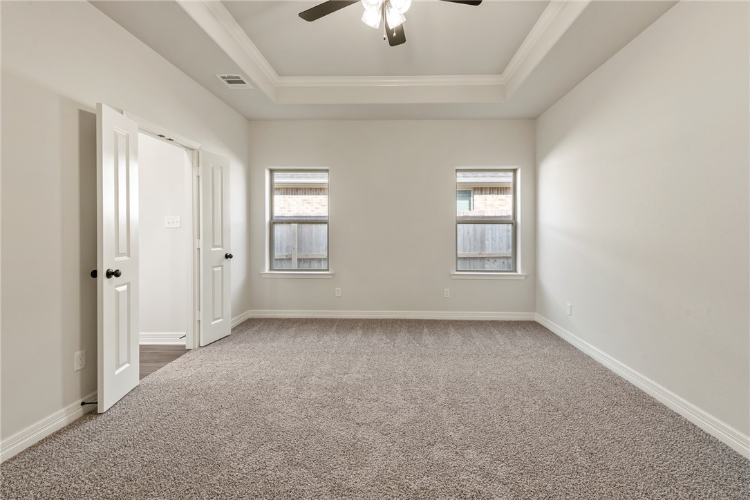 2813 Spector Drive Bryan, TX 77808 - Photo 25 of 42 an empty room with chandelier fan and windows