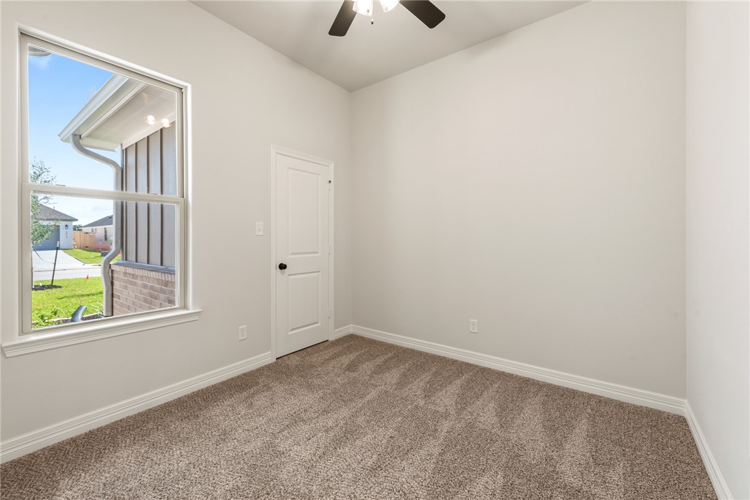 2813 Spector Drive Bryan, TX 77808 - Photo 39 of 42 an empty room with windows and a chandelier fan
