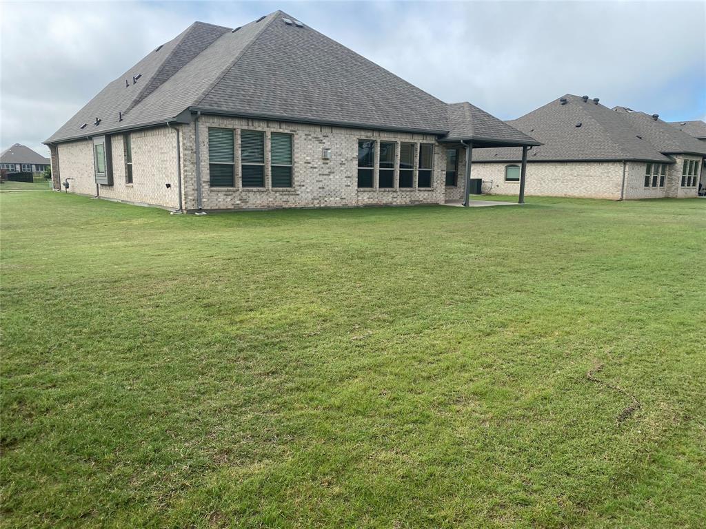 209 Johnson Street Granbury, TX 76048 - Photo 40 of 40 Back of property featuring a patio area and a lawn