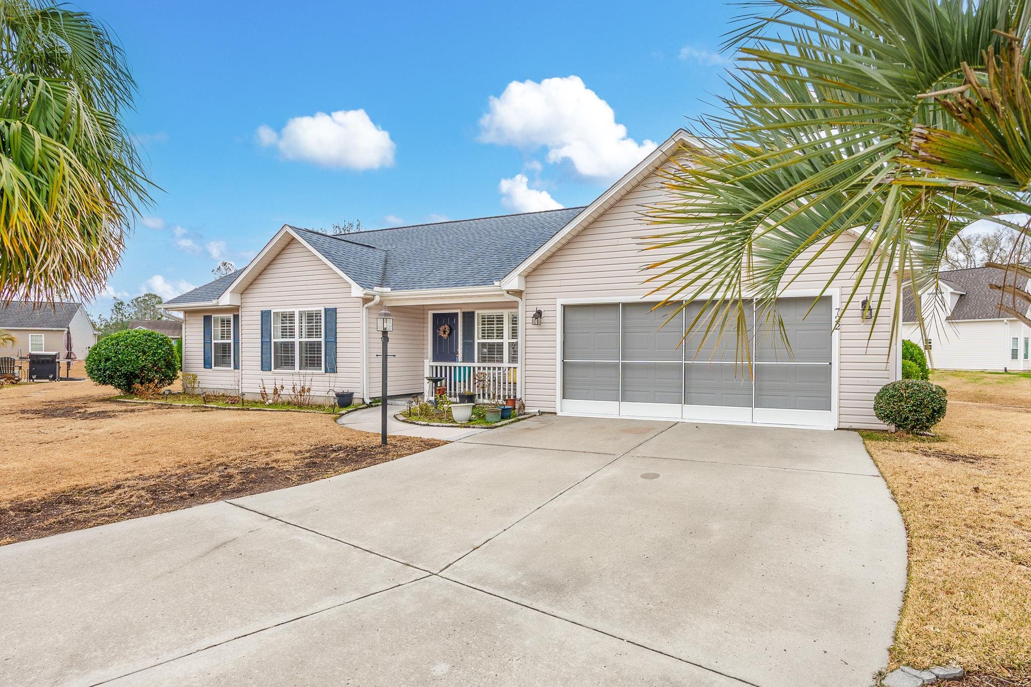 Single story home featuring covered porch, driveway, a garage, and roof with shingles