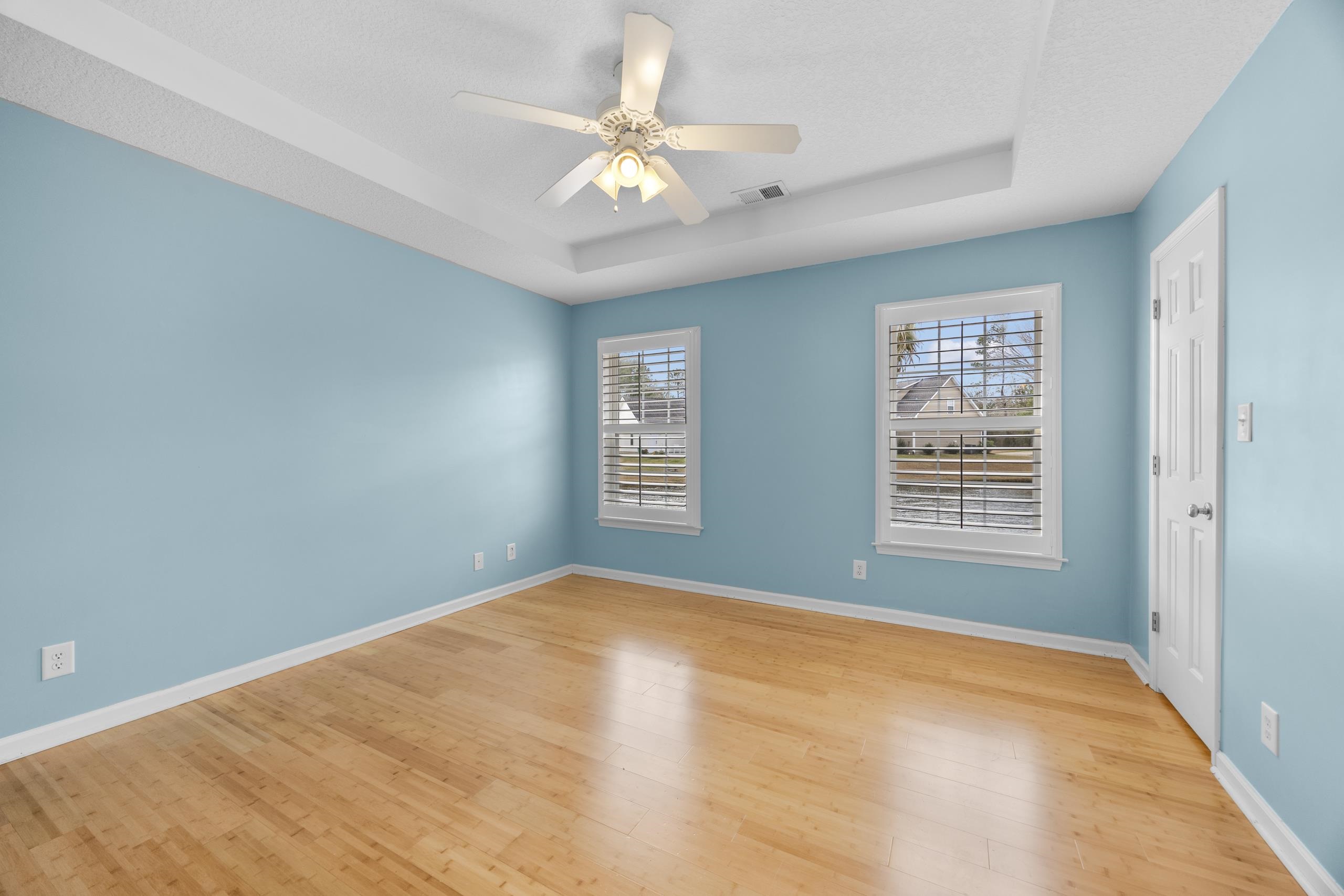 722 Downing Court Longs, SC 29568 - Photo 13 of 40 Bedroom with a tray ceiling, light wood-type flooring, and ceiling fan