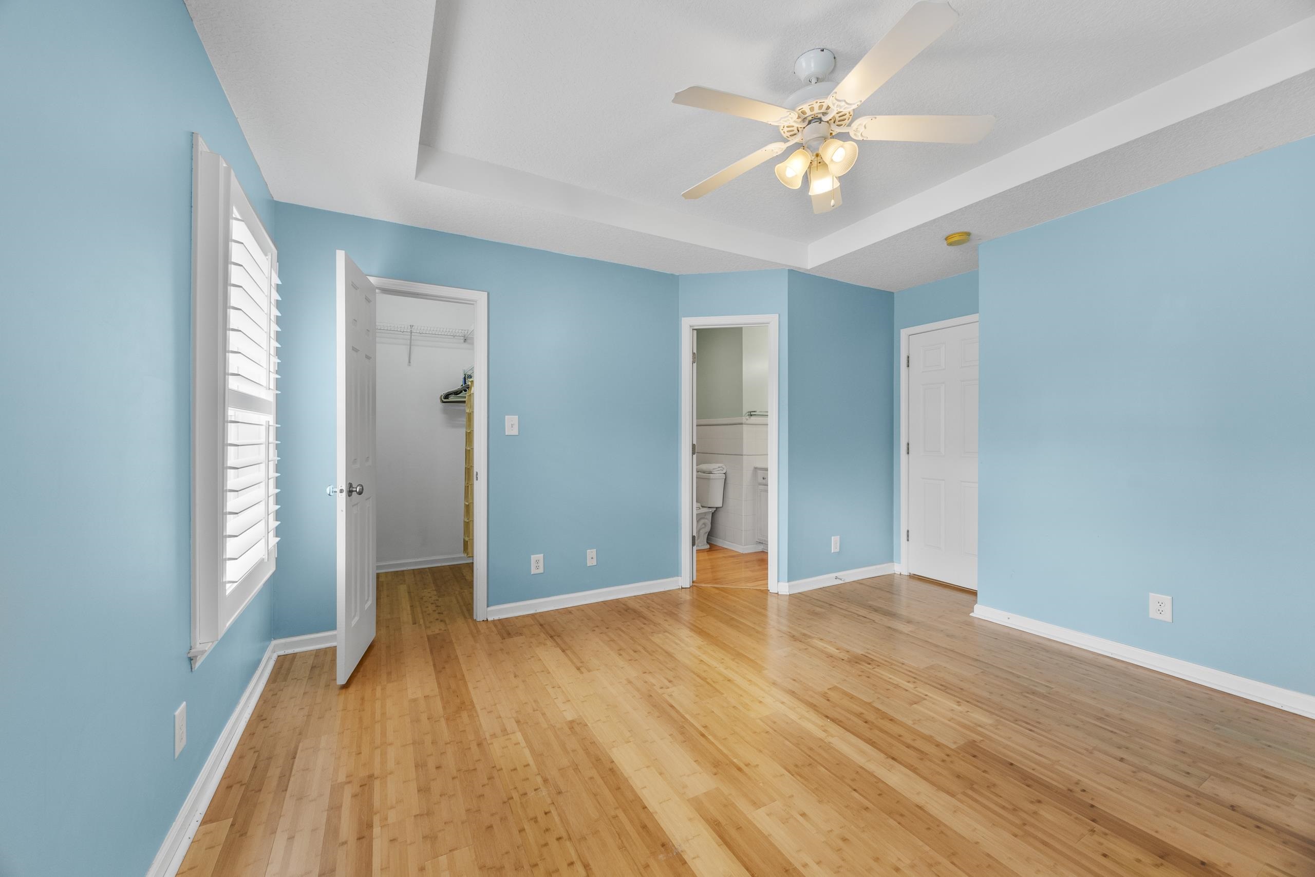 722 Downing Court Longs, SC 29568 - Photo 14 of 40 Master bedroom featuring a spacious closet, light wood-type flooring, a tray ceiling, and a ceiling fan