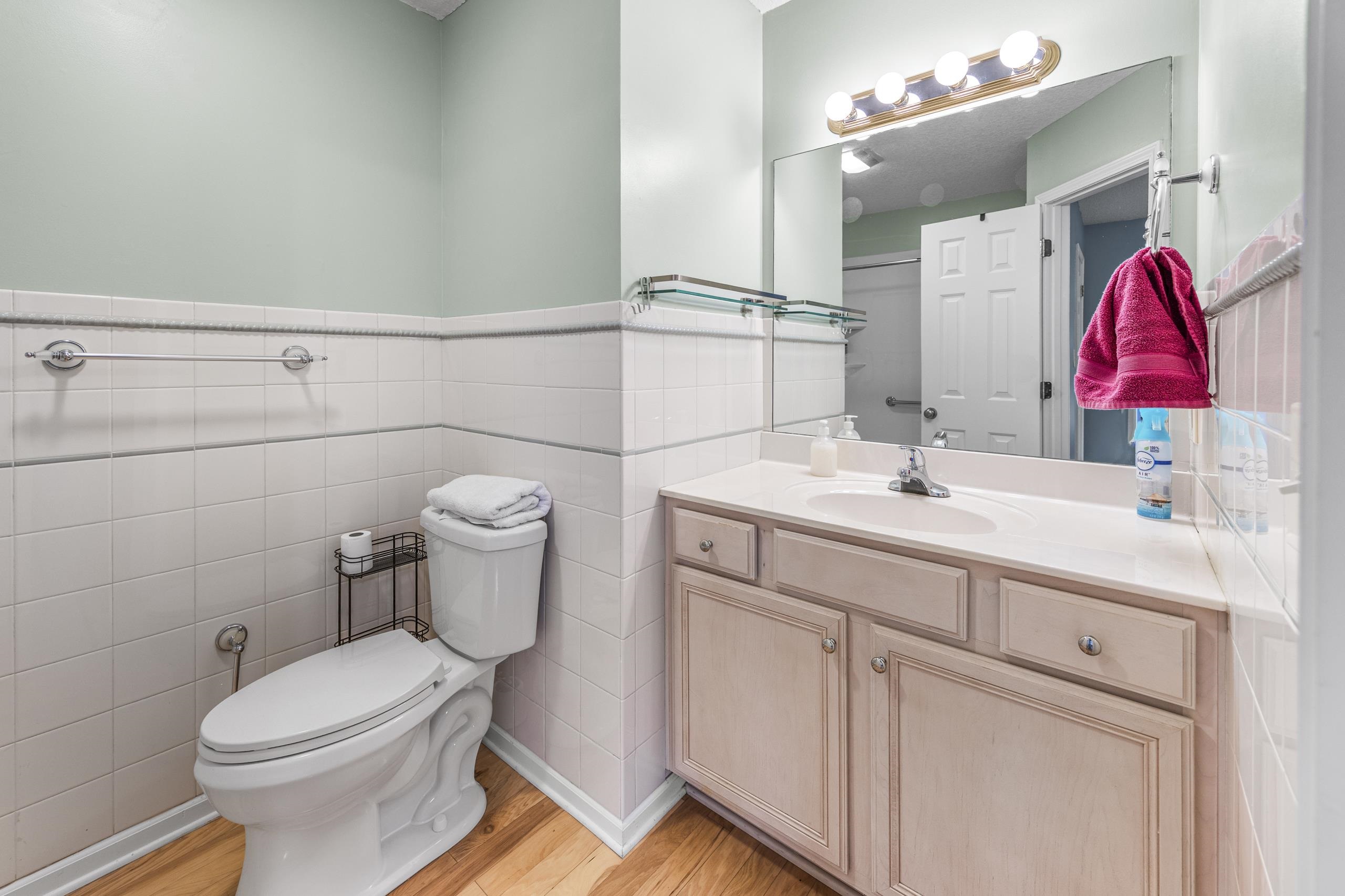 722 Downing Court Longs, SC 29568 - Photo 17 of 40 Bathroom with vanity, tile walls, light wood-type flooring, and wainscoting