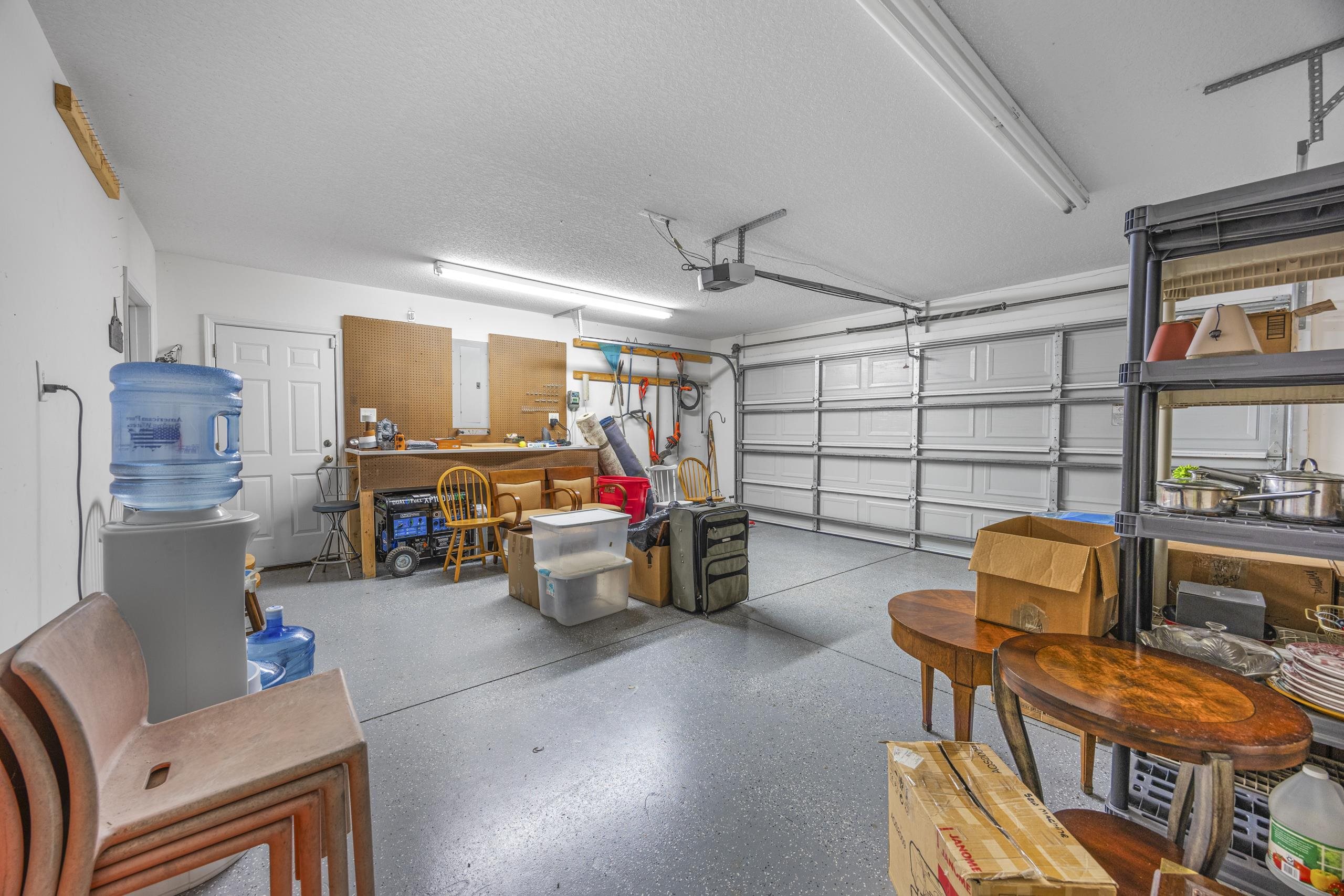 722 Downing Court Longs, SC 29568 - Photo 22 of 40 Garage featuring electric panel, a workshop area, and a garage door opener