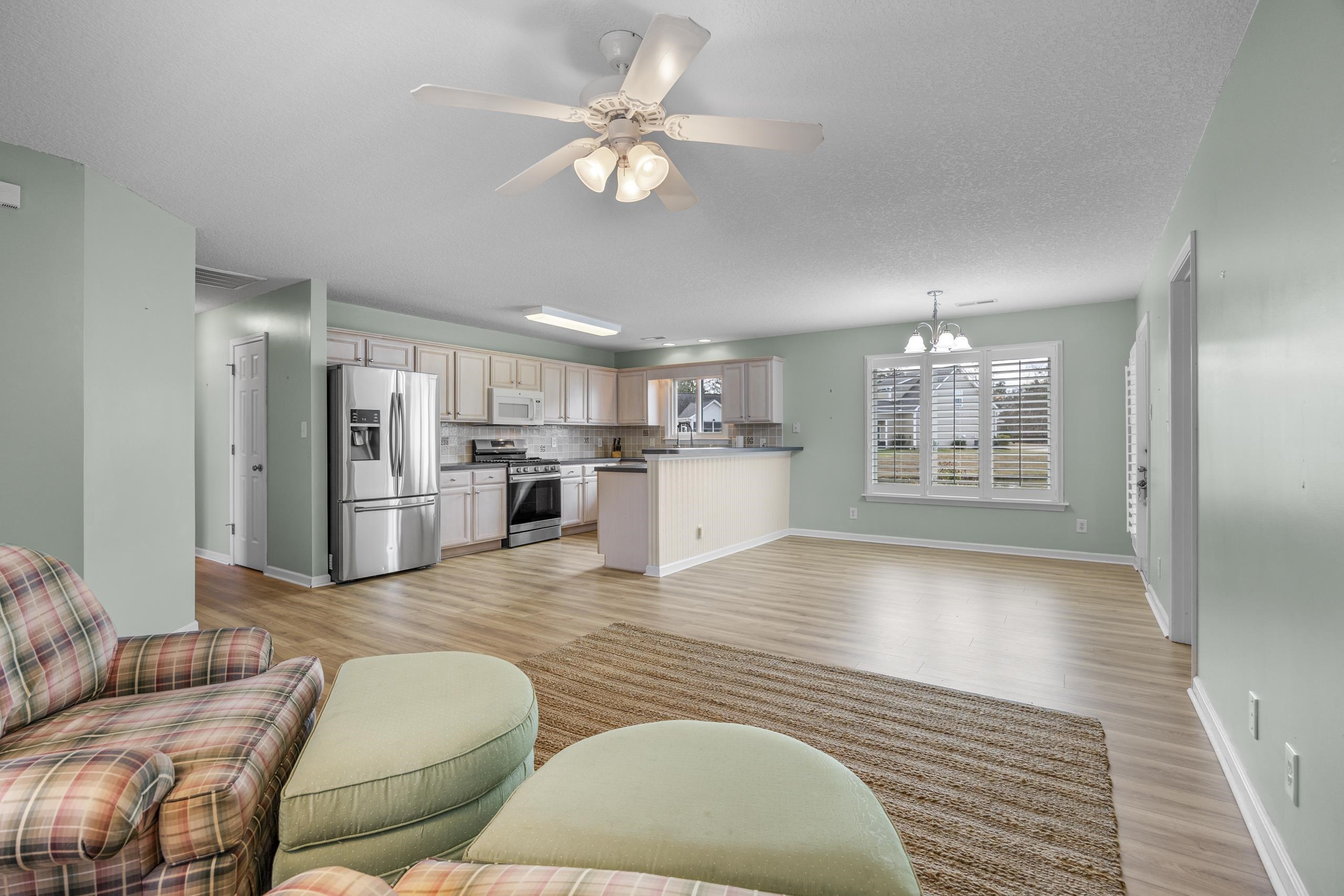 722 Downing Court Longs, SC 29568 - Photo 5 of 40 Living area featuring light wood-style floors, a chandelier, and a ceiling fan
