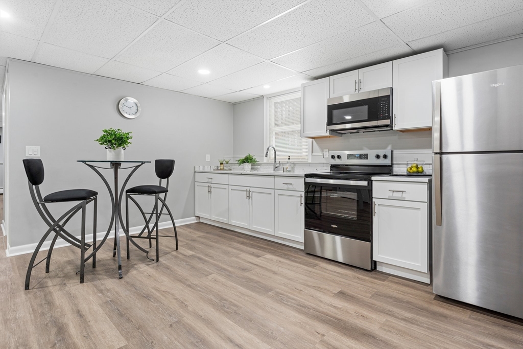 263 Great Road Shirley, MA 01464 - Photo 19 of 30 a kitchen with stainless steel appliances a stove a sink cabinets and a refrigerator