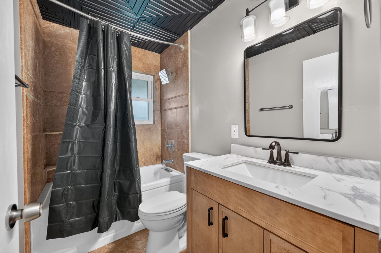 3708 Merrily Way Sacramento, CA 95821 - Photo 26 of 51 Wood-finish vanity with white countertop, rectangular sink, and dark bronze faucet