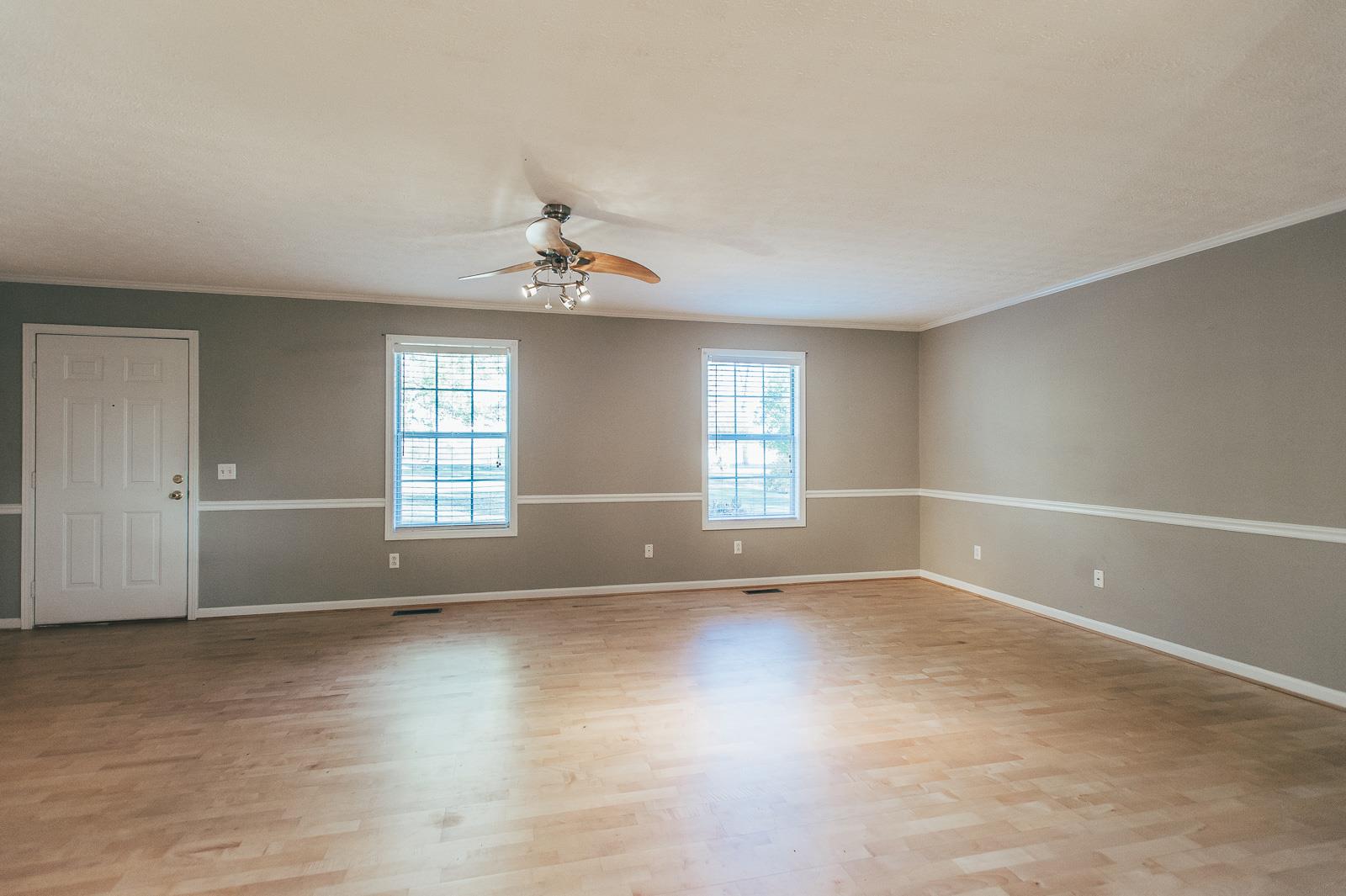 557 S Road Cottontown, TN 37048 - Photo 7 of 24 an empty room with wooden floor and windows