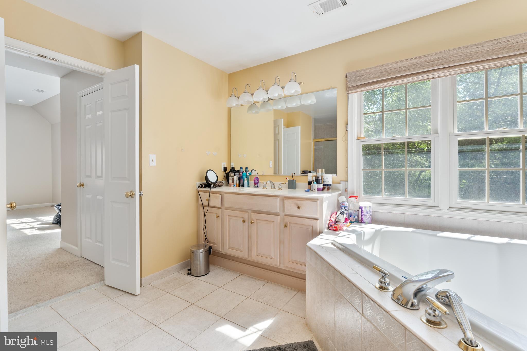 7815 Stable Way Potomac, MD 20854 - Photo 20 of 36 a bathroom with a tub sink and mirror